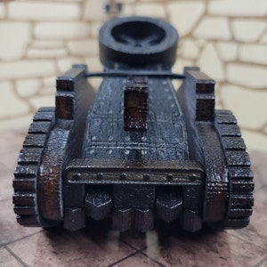 May include: A wooden model of a medieval siege weapon, a catapult, with a dark brown finish and a detailed design. The catapult has a large wheel on each side and a raised platform in the back.