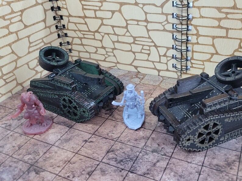 May include: Two miniature, green and black, tracked vehicles with large wheels. A miniature, gray, skeletal figure with a hat and a weapon stands between the vehicles.
