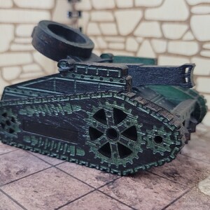 May include: A black and green toy tank with a large, round, black turret. The tank has a detailed design with gears and tracks.