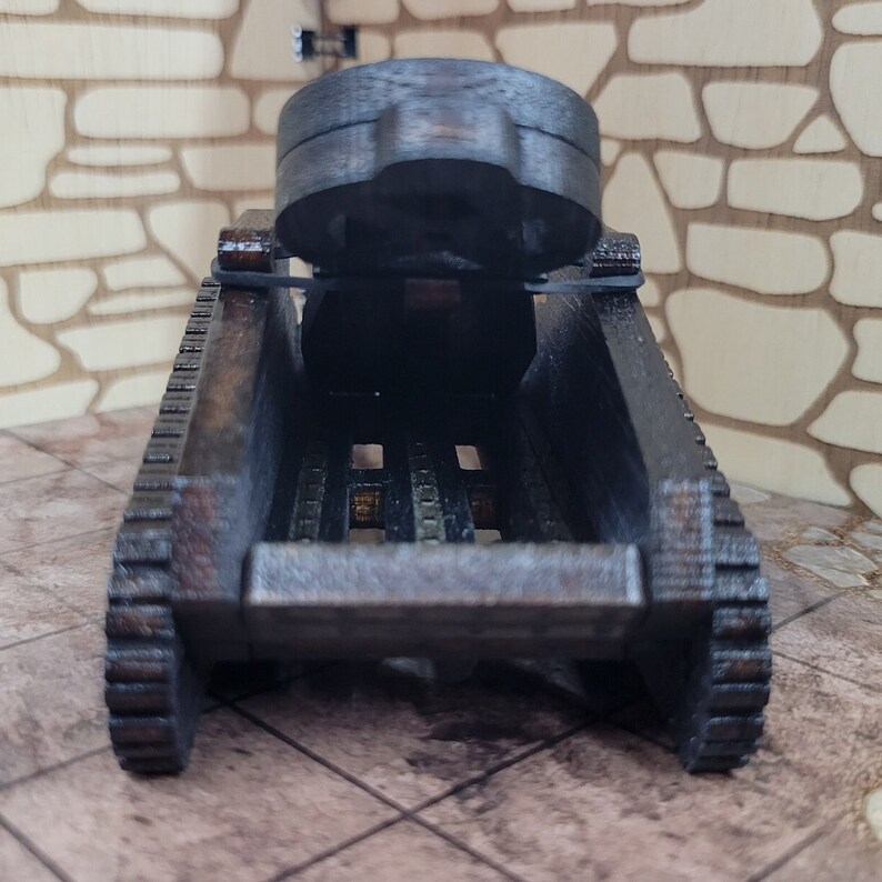 May include: A wooden toy tank with a black paint finish. The tank has a raised cannon and treads on the sides.