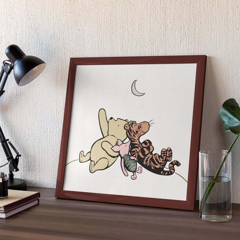 May include: A framed print of Winnie the Pooh, Piglet, and Tigger looking up at a crescent moon. The characters are drawn in a cartoon style and are colored in shades of brown, pink, and orange.