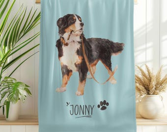 May include: A blue and white beach towel featuring an illustration of a Bernese Mountain Dog and the name "Jonny" printed on it.