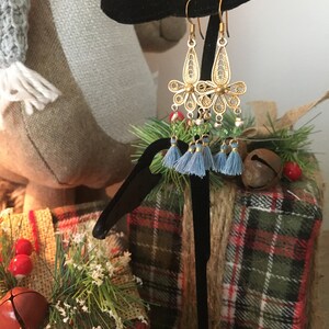 May include: Gold filigree earrings with blue and green beads and tassels.