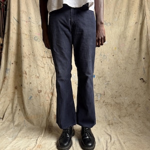May include: A pair of dark navy blue denim jeans with a straight-leg cut, featuring a standard button fly closure and a classic five-pocket design, paired with a plain white short-sleeved t-shirt and black leather lace-up shoes.