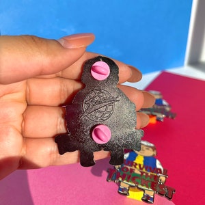 K&ouml;nnte beinhalten: R&uuml;ckansicht einer silbernen Metallstifts mit einer Comicfigur mit dem Text "Survival of the Thickest". Der Stift hat zwei rosa Gummistopfen auf der R&uuml;ckseite.