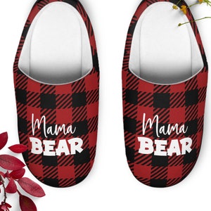 May include: Pair of red and black buffalo plaid slippers with the text "Mama Bear" in white.