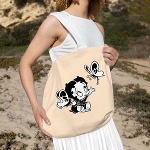 May include: A beige tote bag featuring a black and white cartoon image of a girl with a butterfly. The girl is wearing a dress and has her hair tied back in a ponytail. The butterfly is flying above her head.