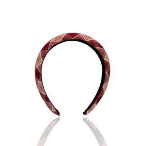 Pu&ograve; includere: Un cerchietto a scacchi rosso e bianco con un elastico nero.