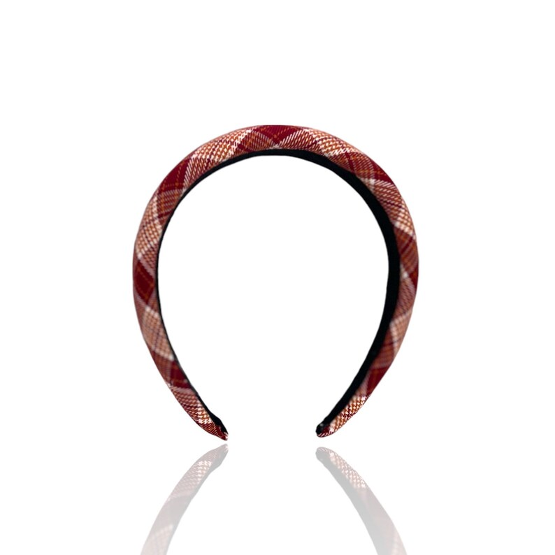 Pu&ograve; includere: Un cerchietto a scacchi rosso e bianco con un elastico nero.
