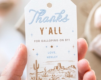 May include: A white thank you tag with blue and gold lettering. The tag says "Thanks Y'all for Galloping On By! Love, Henley". The tag has a desert scene with cacti and mountains.