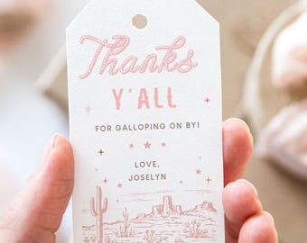 Könnte beinhalten: Ein weißer Geschenkanhänger mit rosa Schrift, auf dem "Thanks Y'all" und "For Galloping On By!" steht, sowie eine rosa und weiße Illustration einer Wüstenlandschaft. Der Text "Love, Joslyn" ist ebenfalls in rosa enthalten.