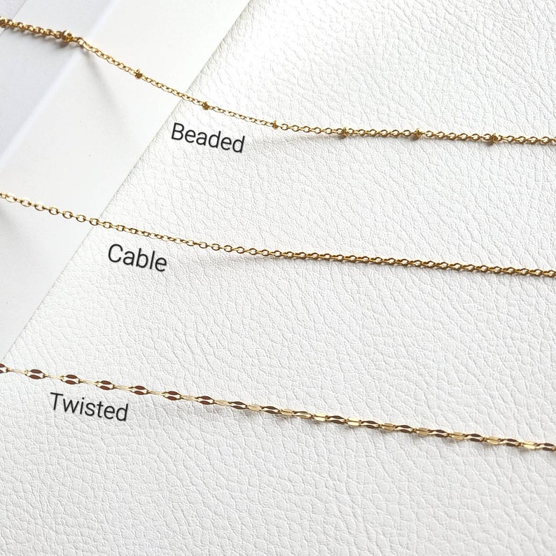 May include: Three gold chains on a white background. The chains are labeled "Beaded", "Cable", and "Twisted".
