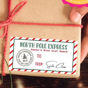 Puede incluir: Un regalo envuelto con una cuerda roja y una etiqueta navideña que dice "North Pole Express Santa's Nice List Award". El regalo está envuelto en papel marrón, con el texto "Editable Christmas Personalized Gift Tags" en la parte superior.
