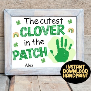 Puede incluir: Un cartel blanco imprimible con tréboles verdes y arcoíris que dice "El trébol más lindo del parche" con una huella de mano verde y el nombre "Alex" debajo. El cartel dice "Descarga instantánea de huella digital" en la parte inferior.