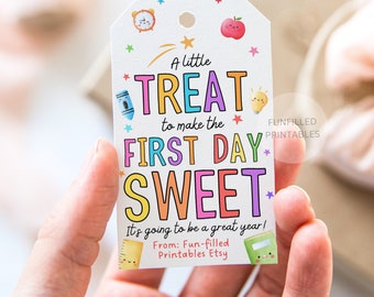 Könnte beinhalten: Ein weißes Geschenk-Etikett mit farbenfrohem Text, der lautet: "A little TREAT to make the FIRST DAY SWEET." Das Etikett enthält Illustrationen von Schulmaterialien und den Text "It's going to be a great year!"