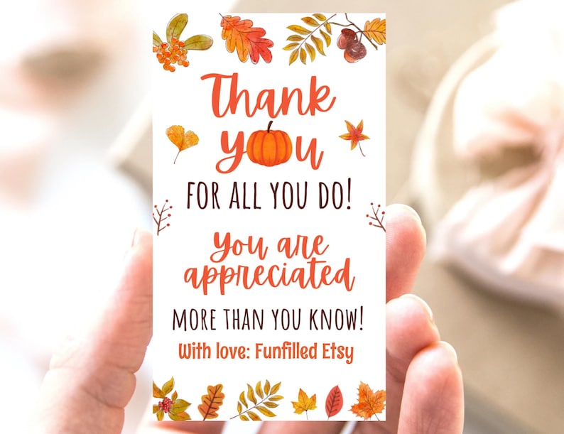 May include: A rectangular card with the words "Thank You" and "For All You Do!" in orange script. The card is decorated with watercolor illustrations of fall leaves and a pumpkin. The text "You are appreciated more than you know!" is also included.