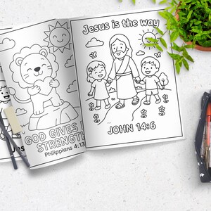 May include: Open coloring book pages with line drawings of a lion holding a heart, Jesus with children, and the text "GOD GIVES STRENGTH" and "Jesus is the way". Pencils and a pencil case are also visible.