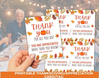 May include: A white Thanksgiving or appreciation card with orange text that reads "Thank You For All You Do!" and "You Are Appreciated More Than You Know!" with a pumpkin and fall leaf design. The card is held by a person.