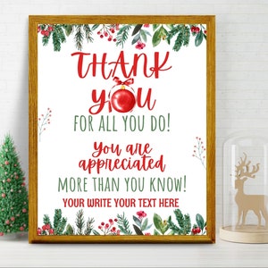 Può includere: Una stampa natalizia incorniciata con le parole "THANK YOU FOR ALL YOU DO!" in rosso e verde. La stampa è decorata con vegetazione festiva e un ornamento rosso. Un piccolo albero di Natale e una decorazione a forma di renna sono sullo sfondo.