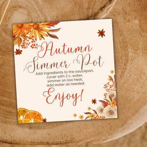 Puede incluir: Una tarjeta cuadrada con fondo crema que presenta ilustraciones florales otoñales en naranja y marrón. El texto dice: Autumn Simmer Pot, Add ingredients to the saucepan, cover with 2 c. water, simmer on low heat, add water as needed. Enjoy!