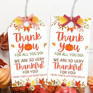 May include: Two white gift tags with the text "Thank You" in orange, a pumpkin illustration, and fall foliage. The tags read "For All You Do! We Are So Very Thankful For You!" and "From: Funfilled Printables."