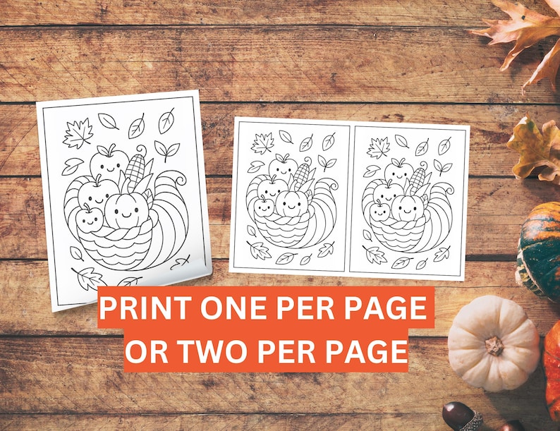 May include: Two black and white coloring pages featuring a cornucopia design with smiling apples, pumpkins, and corn. The text on the image reads "PRINT ONE PER PAGE OR TWO PER PAGE". The pages are on a wooden surface.