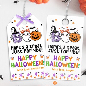May include: Two Halloween gift tags with the word "BOO" spelled out with a witch hat, ghost, and jack-o'-lantern. The tags read "Here's a treat just for you!" and "Happy Halloween!" with a name at the bottom. A purple bow is at the top.