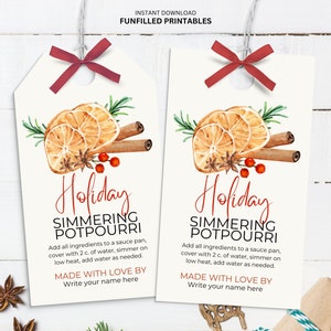 May include: Two white gift tags with watercolor illustrations of orange slices, cinnamon sticks, and star anise. The tags read "Holiday Simmering Potpourri" and include instructions. Each tag is tied with a red ribbon.
