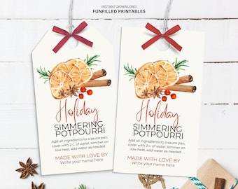 May include: Two white gift tags featuring watercolour illustrations of orange slices, cinnamon sticks, and star anise. The tags say "Holiday Simmering Potpourri" and include instructions. Each tag is tied with a red ribbon.