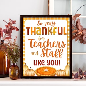 May include: A framed print with the text "So very THANKFUL for Teachers and Staff Like YOU!" in orange and yellow. The print features pumpkins and a pie illustration. The frame is dark brown.