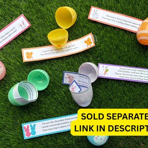 May include: A set of plastic Easter eggs with bunny faces and colorful stripes. Each egg contains a small card with a riddle or clue for an Easter egg hunt. The cards have text such as "The bunny built a tower - then what a mess! Your clue is hiding where bricks take a rest!" and "Bunny ears need washing too, with bubbly stuff just like you do! Hop to the bottles that clean your hair. Your next clue is hiding there!"
