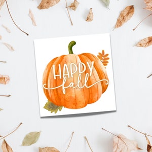 May include: A white card with a watercolor illustration of an orange pumpkin with the text "Happy Fall" in white script.