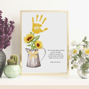 Puede incluir: Una impresión de acuarela con una huella de mano amarilla, girasoles y una jarra de metal con un lazo amarillo. La impresión incluye el texto "Como una flor no puede florecer sin sol, no puedo vivir sin ti. Eres la mejor mamá y gracias por todo lo que haces. Hecho con amor por."