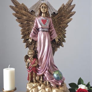 Puede incluir: Estatua detallada de un ángel con grandes alas de color bronce y una túnica rosa. Un pequeño querubín está de pie a los pies del ángel. También se presenta una paloma y un corazón. La base de la estatua tiene el texto "Archangel Metatron".