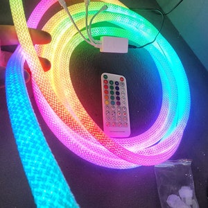 May include: A rainbow LED light strip with a remote control and extra connectors. The light strip is coiled up and the remote control is white with black buttons. The connectors are in a clear plastic bag.