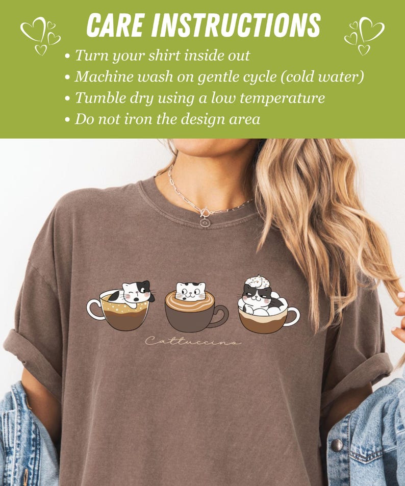 Puede incluir: Una camiseta marr&oacute;n con un gr&aacute;fico de tres gatos en tazas de caf&eacute;. El texto "Cattuccina" est&aacute; impreso debajo del gr&aacute;fico. Las instrucciones de cuidado est&aacute;n impresas en un fondo verde en la parte superior de la imagen. Las instrucciones son: Dale la vuelta a tu camiseta, Lava a m&aacute;quina en ciclo suave (agua fr&iacute;a), Seca en secadora a baja temperatura, No planches el &aacute;rea del dise&ntilde;o.
