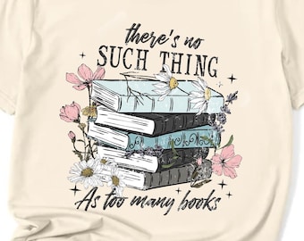 Op de afbeelding: Crèmekleurig T-shirt met een afbeelding van een stapel boeken versierd met bloemen. De tekst "there's no SUCH THING As too many books" staat boven en onder de boekenillustratie. Het shirt heeft een ronde hals en korte mouwen.