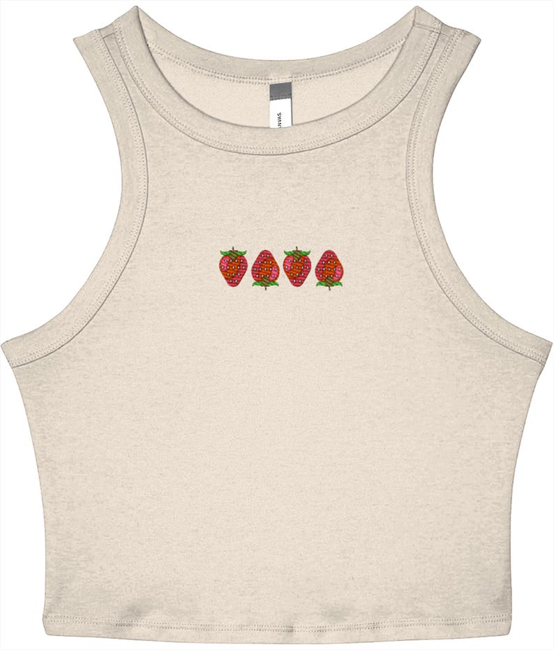 May include: A cream-coloured crop top with a scoop neck and embroidered strawberries. The strawberries are red with green leaves and are embroidered in a row across the chest. The top is sleeveless and made of a soft material.