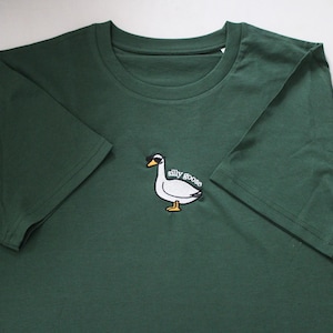 May include: A dark green t-shirt with a white embroidered goose wearing sunglasses and the text "silly goose".