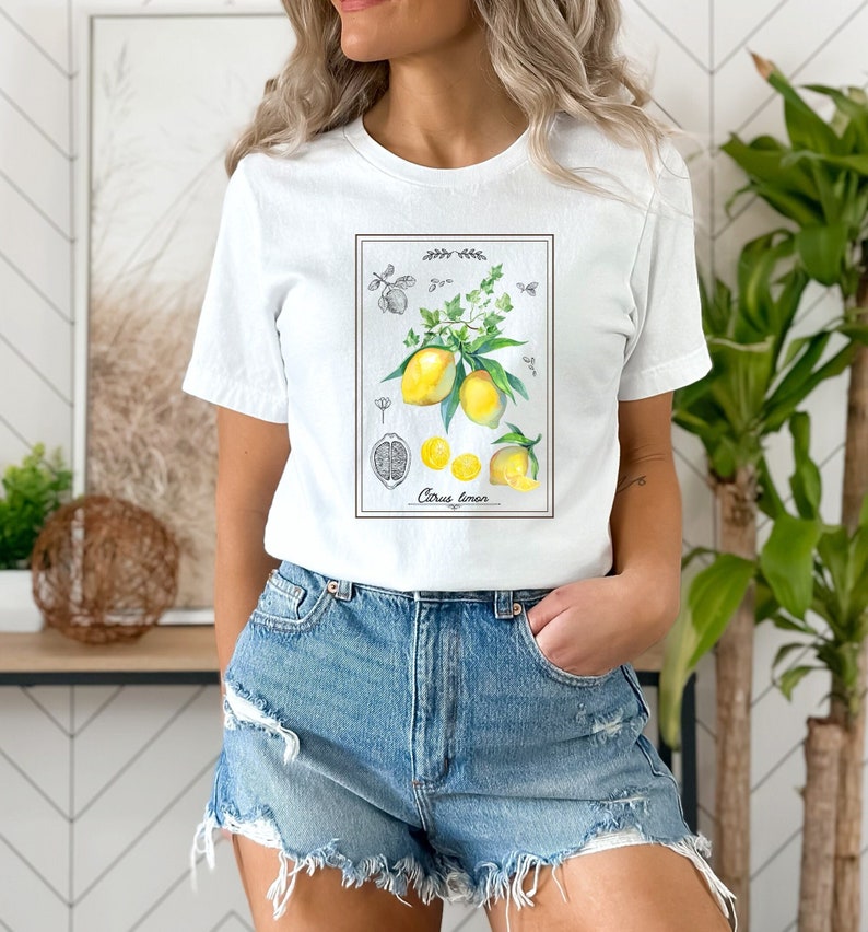 K&ouml;nnte beinhalten: Wei&szlig;es T-Shirt mit einem Aufdruck eines Zitronenzweigs und dem Text "Citrus limon".