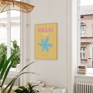 Palm beach florida text in pink and white on a yellow background with a blue flower illustration