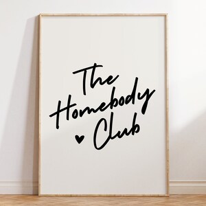 Cream background with The HomebodyClub written in black cursive 
 font with a black heart