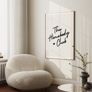 Cream background with The HomebodyClub written in black cursive 
 font with a black heart