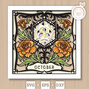 May include: A layered paper art piece featuring orange marigold flowers and green leaves. A geometric shape is in the center, with the word "OCTOBER" below. The design is framed in black with a white border. Includes SVG, EPS, and DXF file formats.