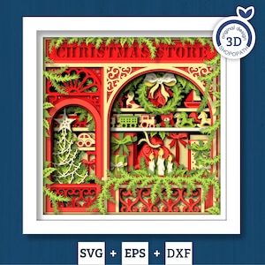 Op de afbeelding: Een gelaagd papierkunstwerk van een kerstwinkelscène. Het rode bord leest "Christmas Store" boven een display van speelgoed, cadeaus en een krans. Groene guirlande en een witte lijst omringen de scène. Inclusief SVG-, EPS- en DXF-bestandsformaten.