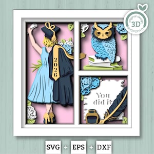May include: A layered paper art piece in a white frame, featuring a graduation theme. It includes a graduate in a blue dress, an owl on books, and the text "You did it." The year "2026" is visible on the graduation gown.