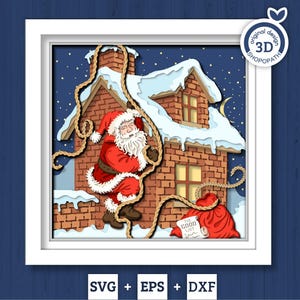 May include: A layered paper art piece featuring Santa Claus climbing down a rope towards a brick house with snow on the roof. A red sack labeled "The Good List" sits below. The artwork is framed in white.