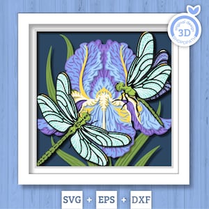 May include: A framed 3D paper art piece featuring two dragonflies and a purple iris flower. The dragonflies have green bodies and light blue wings. The iris has purple petals with yellow and white accents. The artwork is set against a dark blue background.