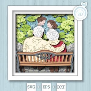 May include: A 3D paper art piece in a white frame. The artwork depicts an elderly couple on a bench, embracing, with a younger couple in the background. The scene is set in a garden with lily pads. The bottom of the frame shows the text "SVG + EPS + DXF".