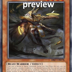 May include: A trading card for the game Yu-Gi-Oh! featuring the Egyptian Divinity Anubis, a dark beast-warrior with a golden headdress and a staff. The card text reads "If this card is Normal or Special Summoned: During your Main Phase this turn, you can Tribute Summon 1 monster, in addition to your Normal Summon/Set (You can only gain this effect once per turn.) This card can be treated as 3 Tributes for the Tribute Summon of a DIVINE monster. If this card is Tributed for a Tribute Summon, during your next Standby Phase: You can Special Summon this card from your GY. You cannot Special Summon monsters from the Extra Deck during the turn you activate this effect."